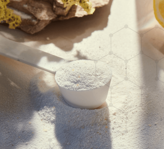 A scooping spoon filled with creatine powder on a table.