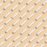 Pills laid out on a tan background in a checkerboard pattern.